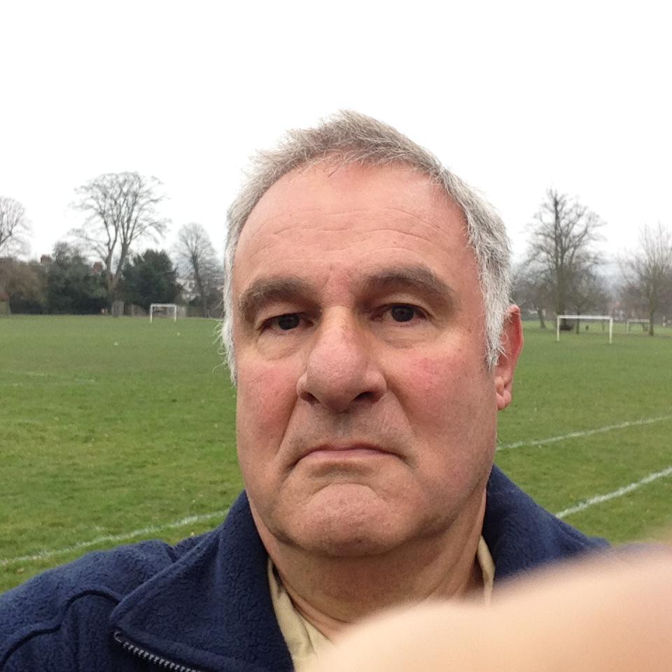 a man taking a selfie in front of a soccer field