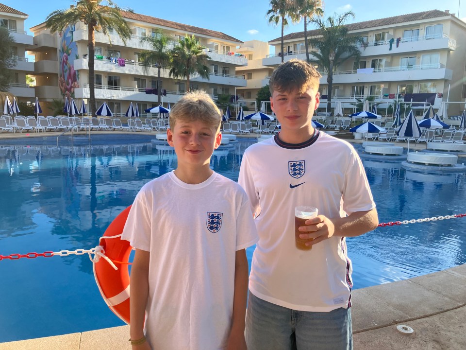 two boys standing next to a pool wearing england shirts