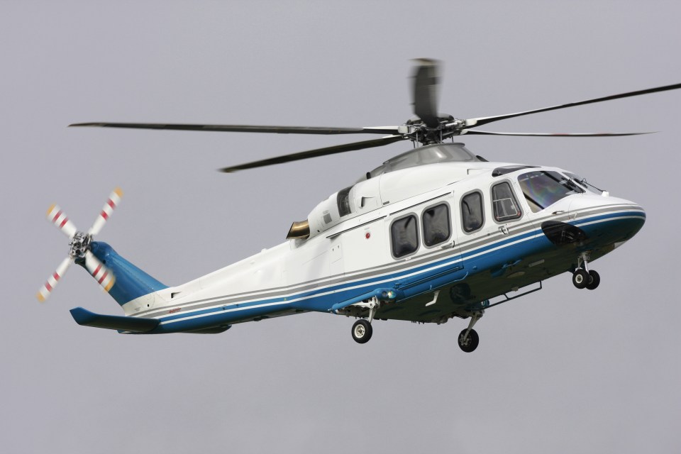 a blue and white helicopter is flying in the sky