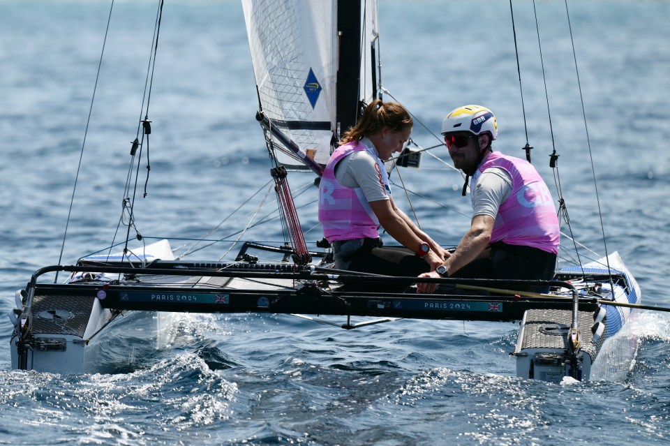 a man and a woman on a sailboat that says paris 2024
