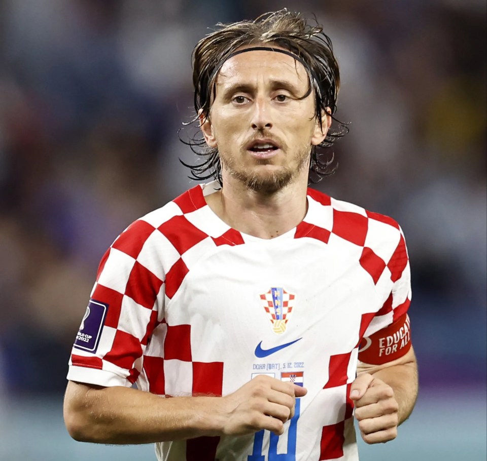 a man wearing a red and white checkered shirt with the number 11 on it