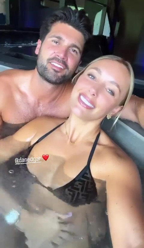 a man and a woman are taking a selfie in a hot tub .