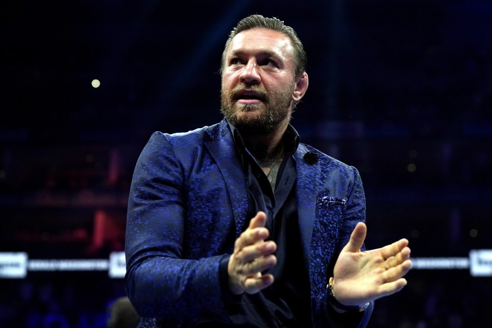 a man in a blue suit is clapping his hands