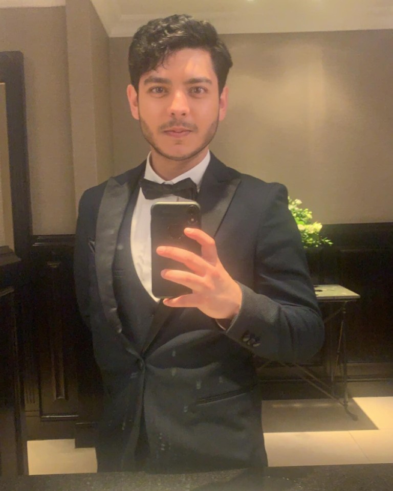 a man in a tuxedo takes a selfie with his phone