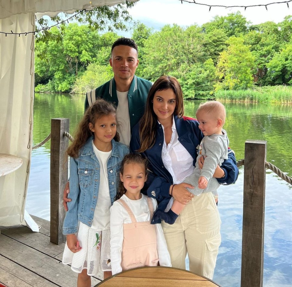 a family posing for a picture in front of a lake
