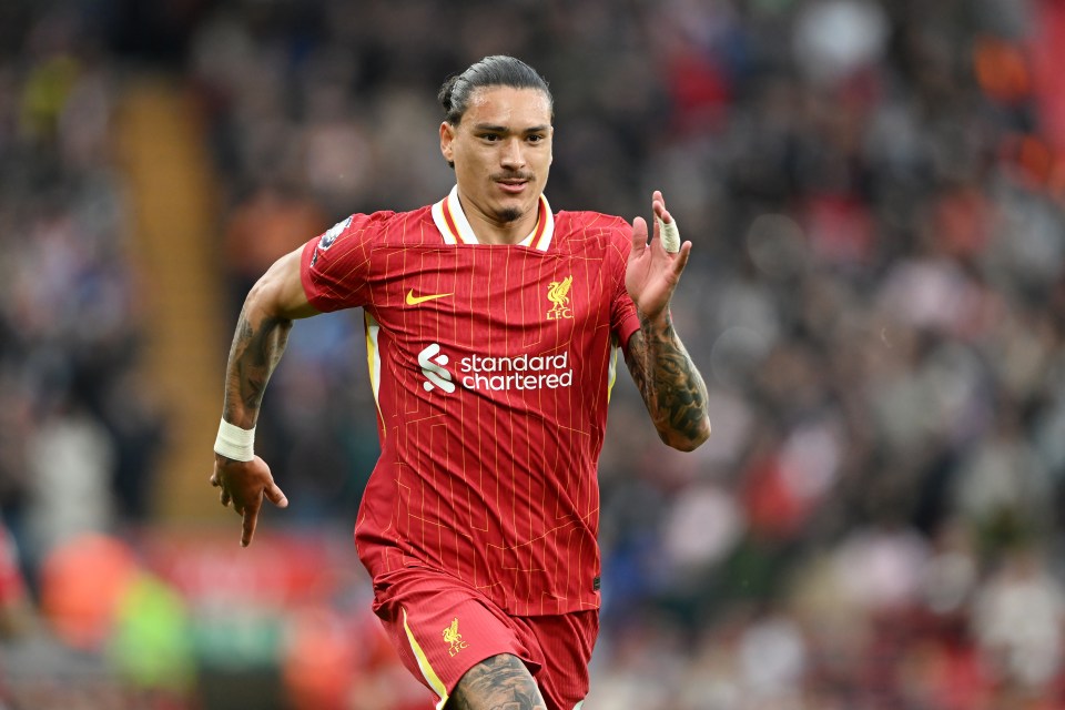 a soccer player wearing a red jersey that says standard chartered