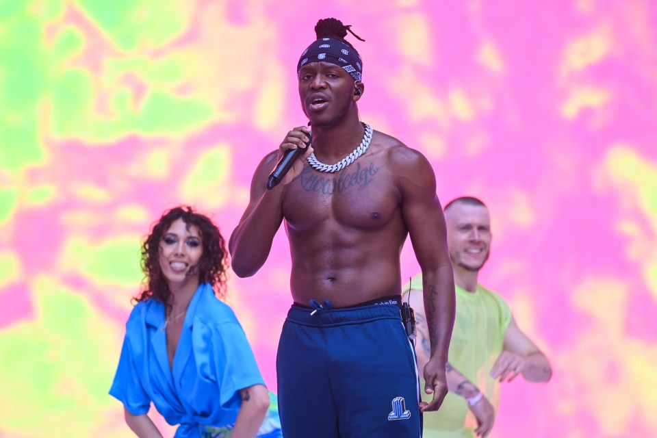 a man without a shirt is singing into a microphone