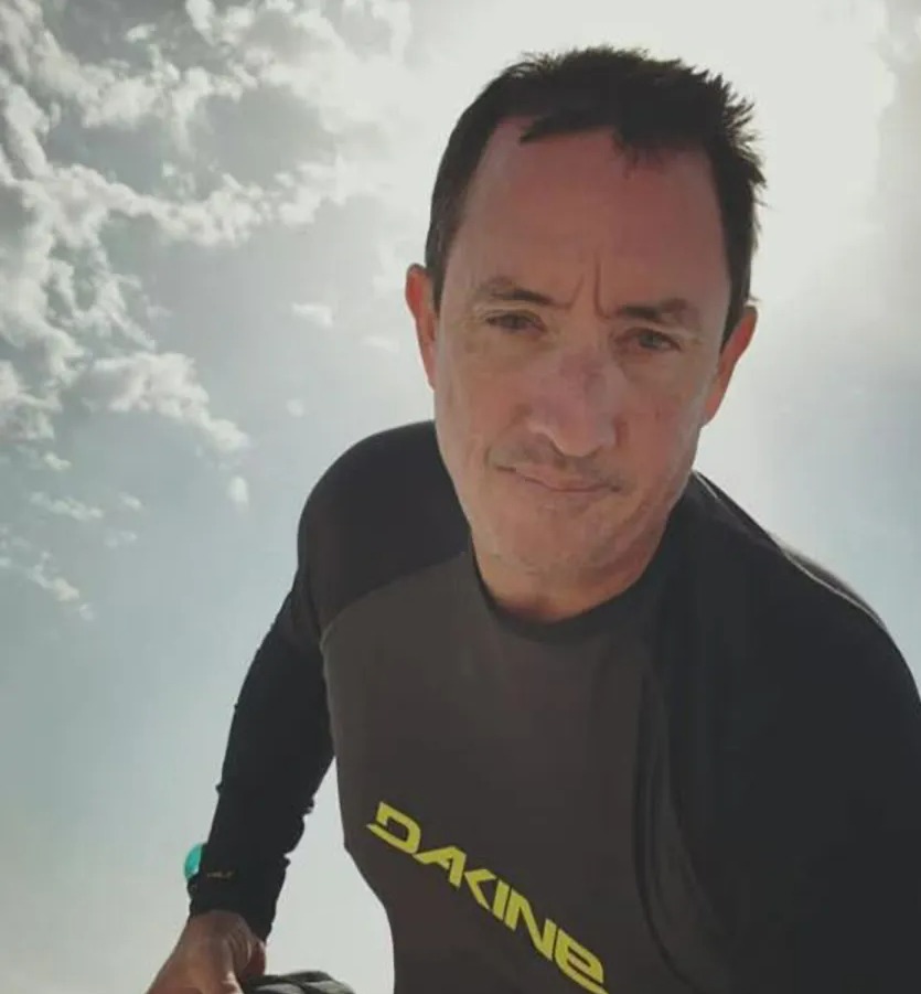 a man wearing a dakine shirt looks at the camera