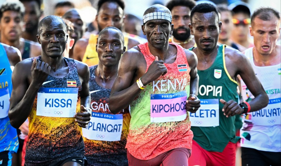 a man in a kenya shirt stretches his leg