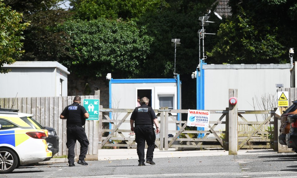 two police officers standing in front of a warning sign