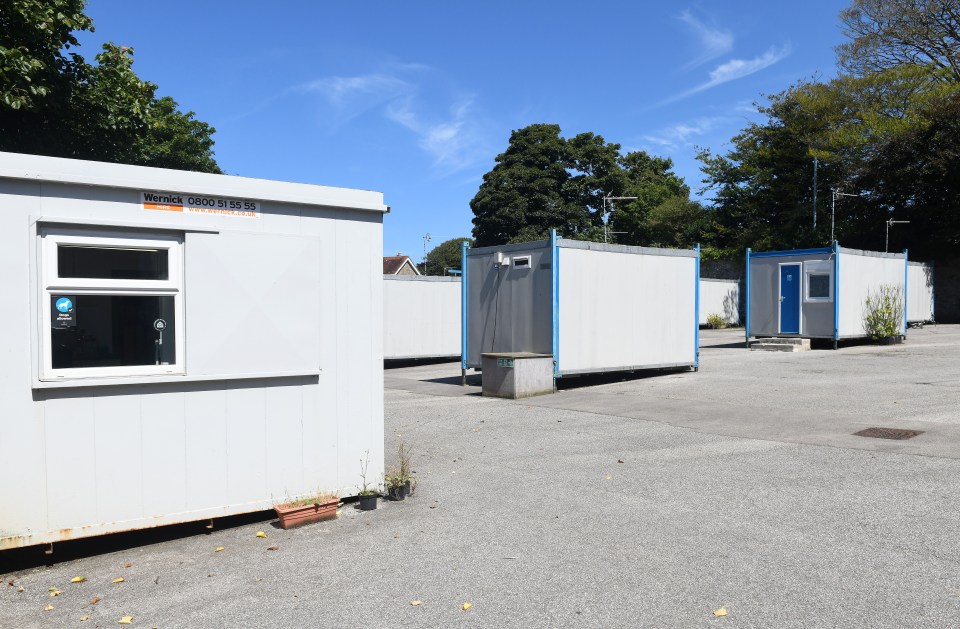 a row of white containers with a sign that says ' hire ' on it