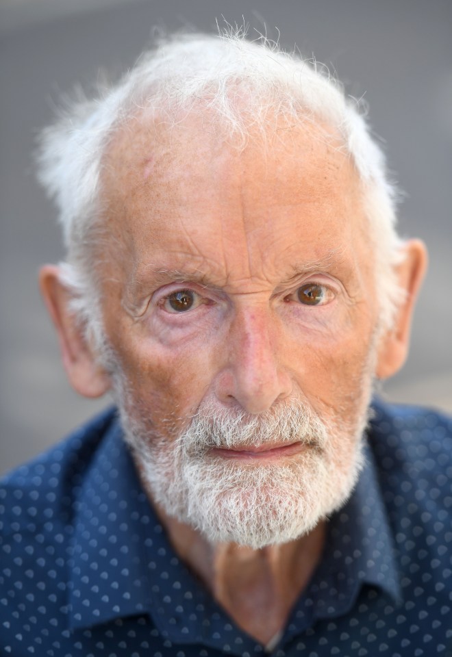 a man with gray hair and a beard is wearing a blue shirt