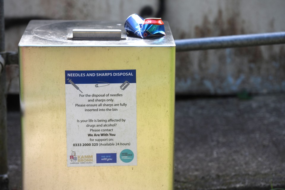 a yellow box with a sign on it that says needles and sharps disposal