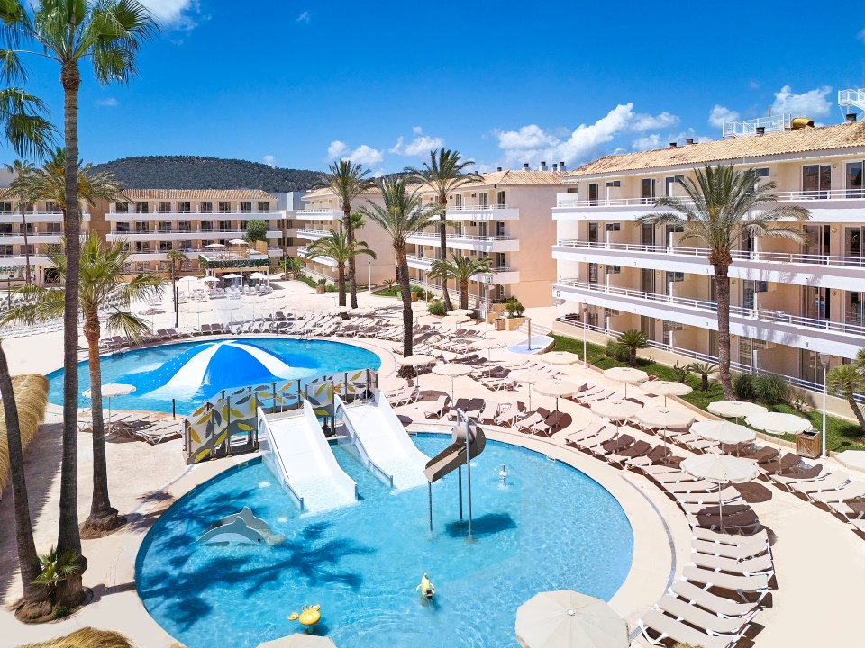 a large swimming pool with a water slide in the middle