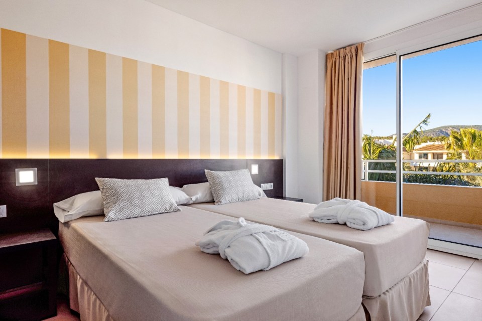 a hotel room with two beds and a balcony