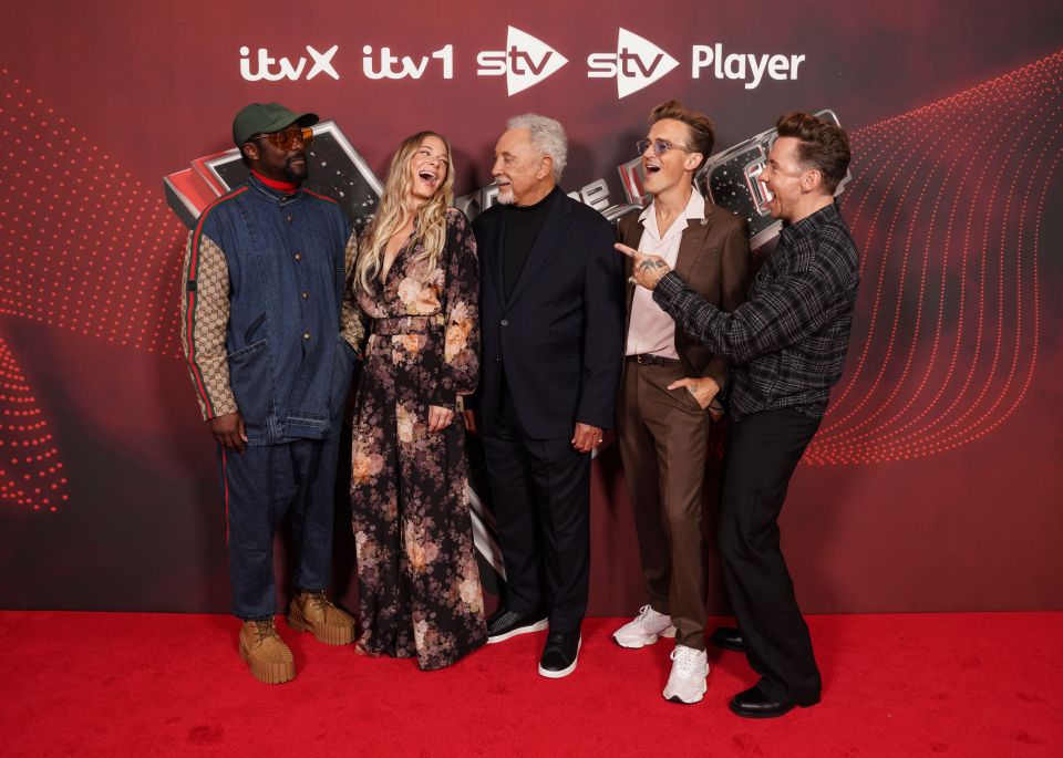 a group of people standing on a red carpet in front of a sign that says itv player