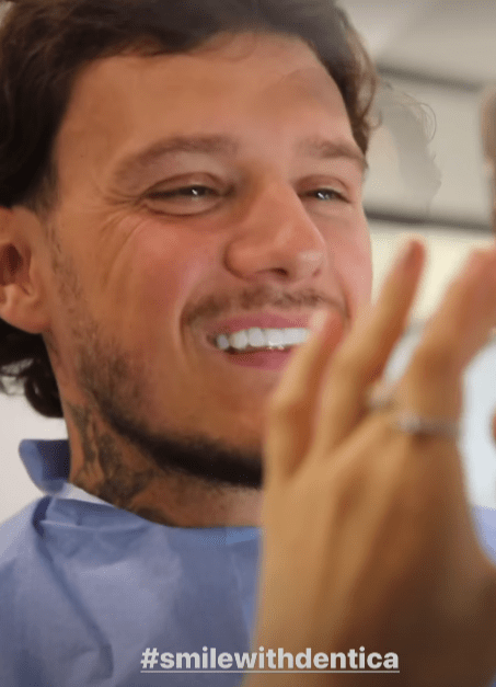 a man is smiling in front of a mirror with #smilewithdentica written on the bottom