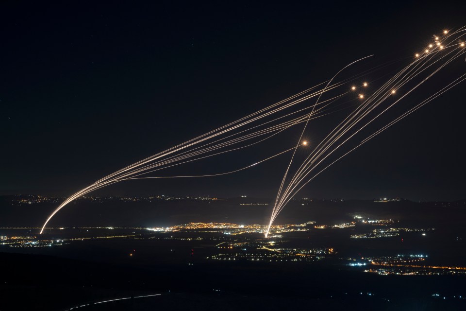 a bunch of lights are flying over a city at night