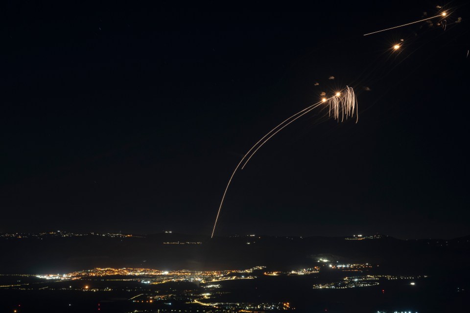 a fireworks display is going off over a city at night