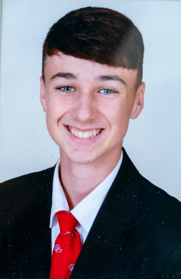 a young man in a suit and tie smiles for the camera
