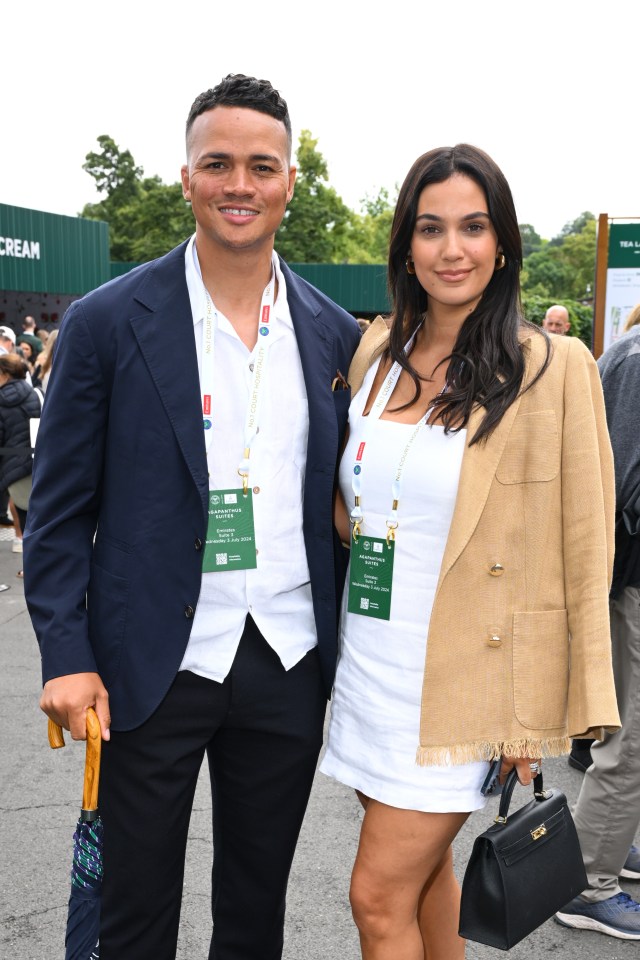 a man and a woman pose for a picture in front of a crowd