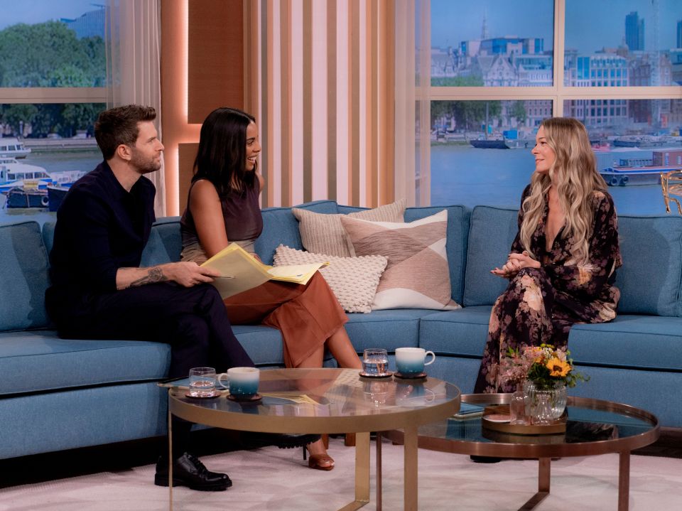 a man and two women sit on a couch talking