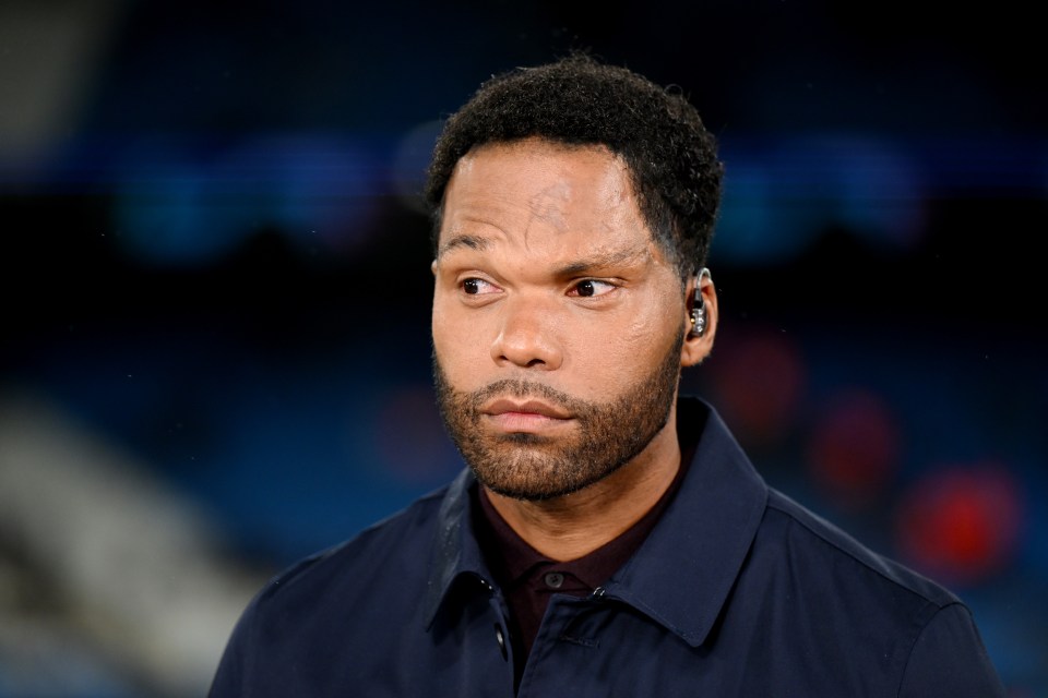 a man with a beard wearing ear buds looks at the camera