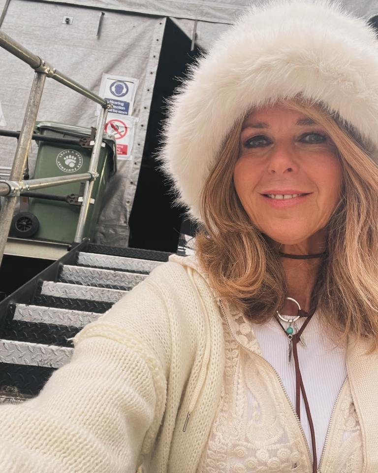 a woman wearing a white fur hat stands in front of stairs