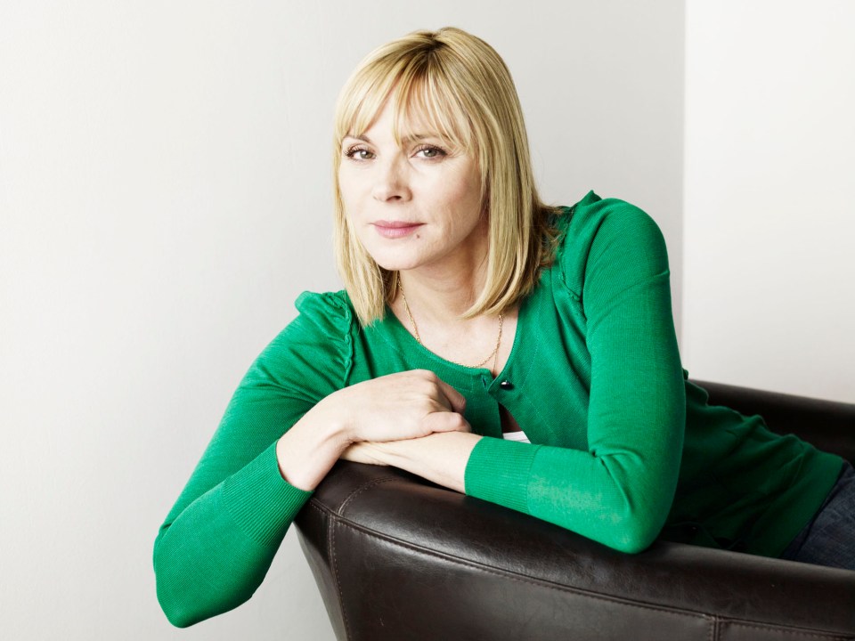 a woman in a green sweater sits in a chair