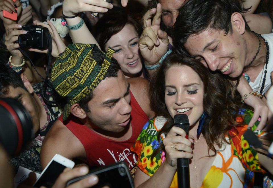 a group of people are gathered around a woman singing into a microphone