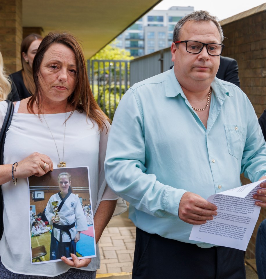 a man and a woman holding a picture of a woman holding a trophy