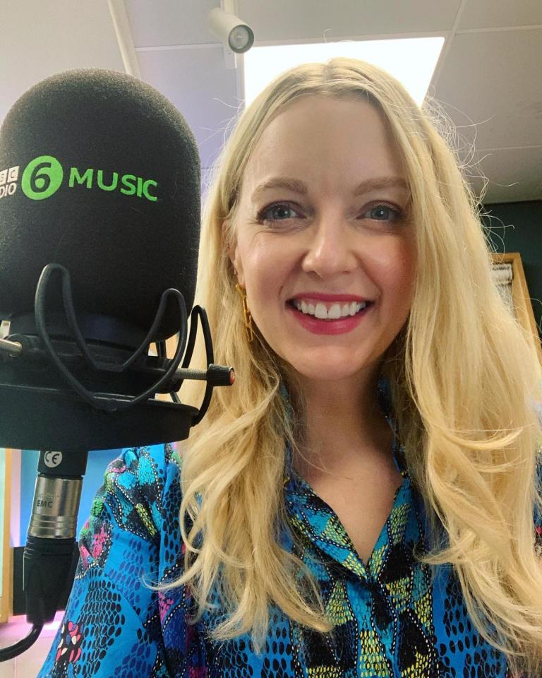 a woman stands in front of a microphone that says 6 music