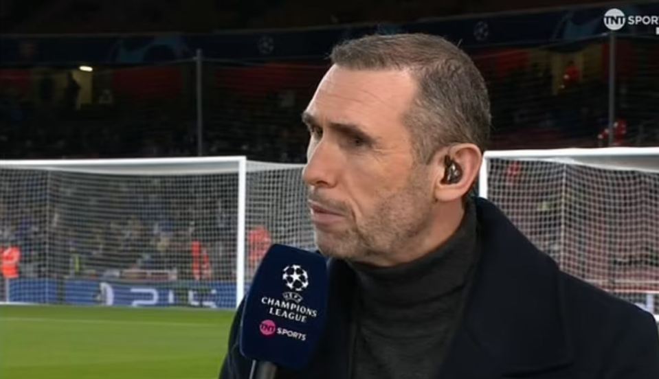 a man is talking into a microphone on a soccer field .