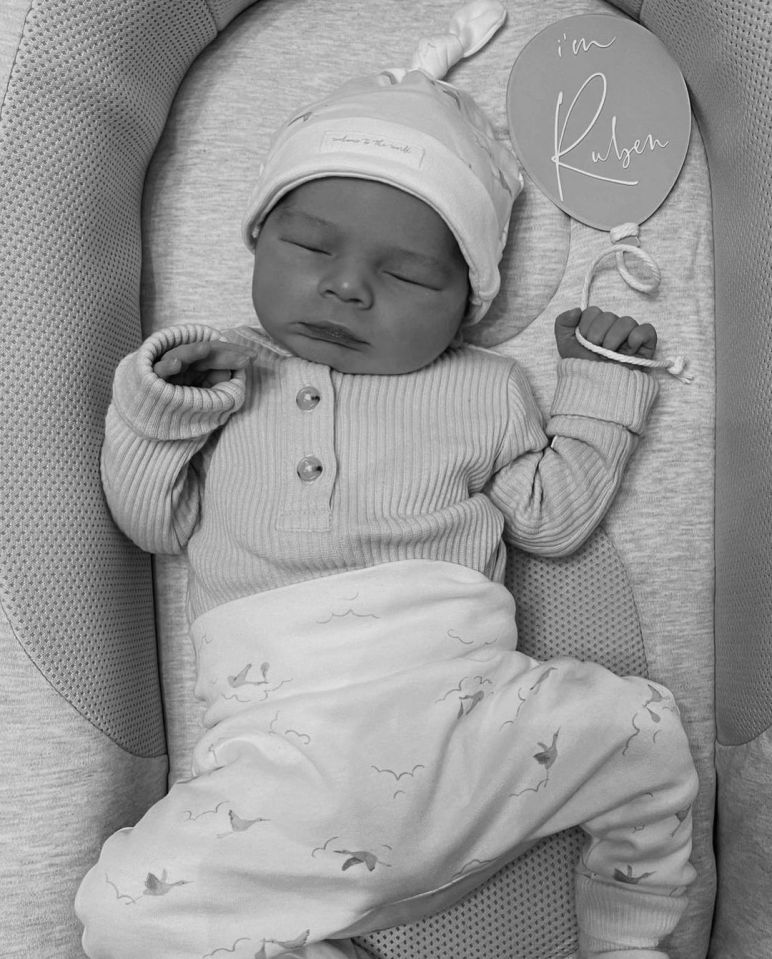 a baby is sleeping in a crib with a sign that says i 'm ruben