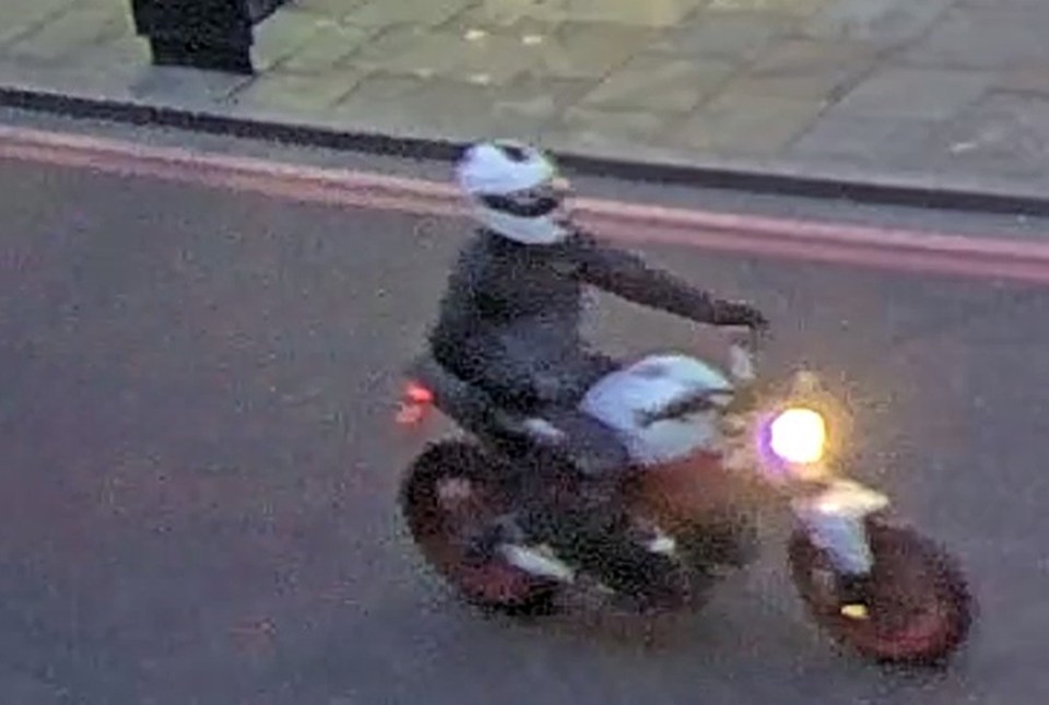 a man is riding a motorcycle down a street at night .