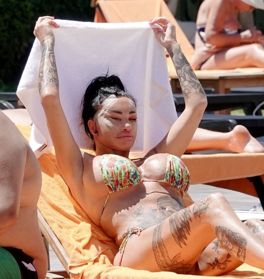 a woman in a bikini is holding a towel over her head