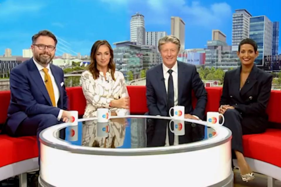 a group of people sitting around a table with cups that say cbs on them