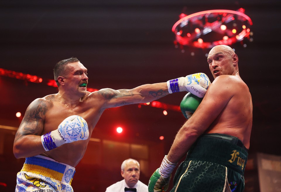 a boxing match between two men one of whom is wearing shorts that say fury