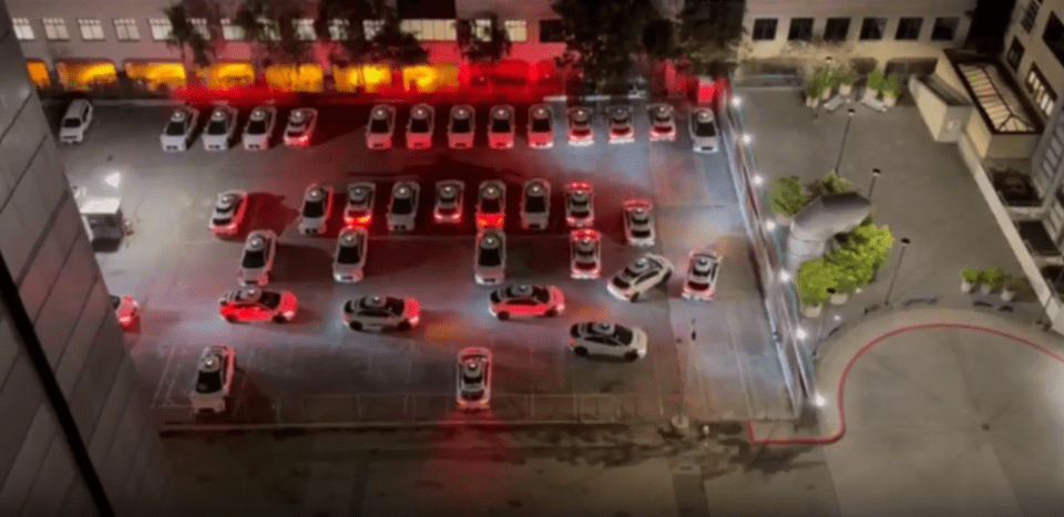 a lot of cars are parked in a parking lot at night