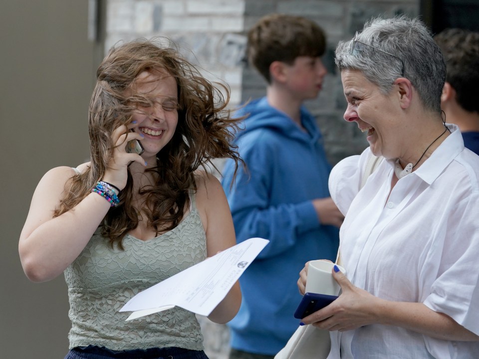 a woman in a denim jacket holds a piece of paper in her hand