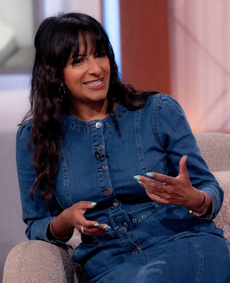 a woman in a denim dress is sitting in a chair
