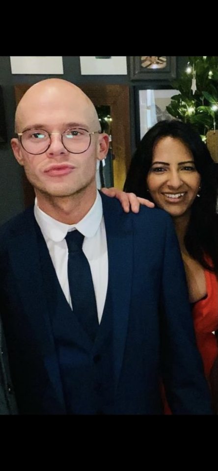 a man in a suit and tie is standing next to a woman in a red dress .