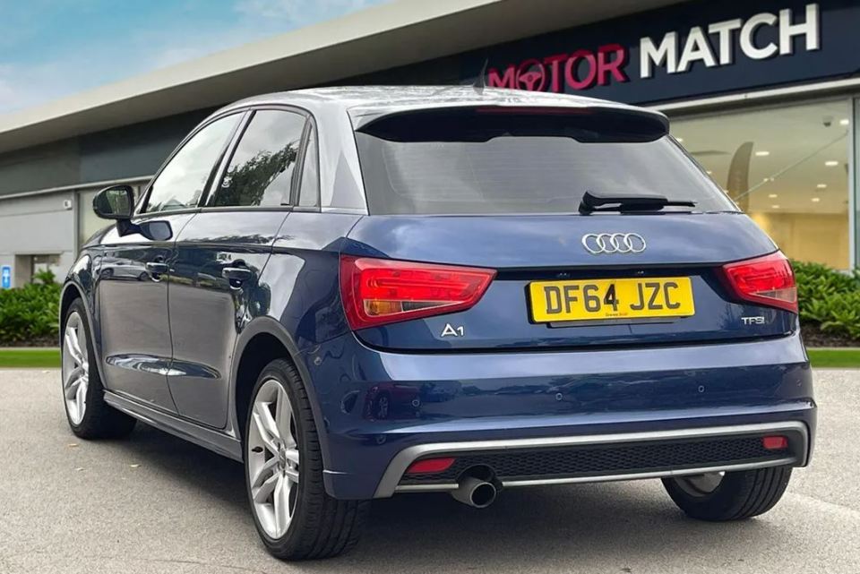 a blue audi a1 is parked in front of a motor match store