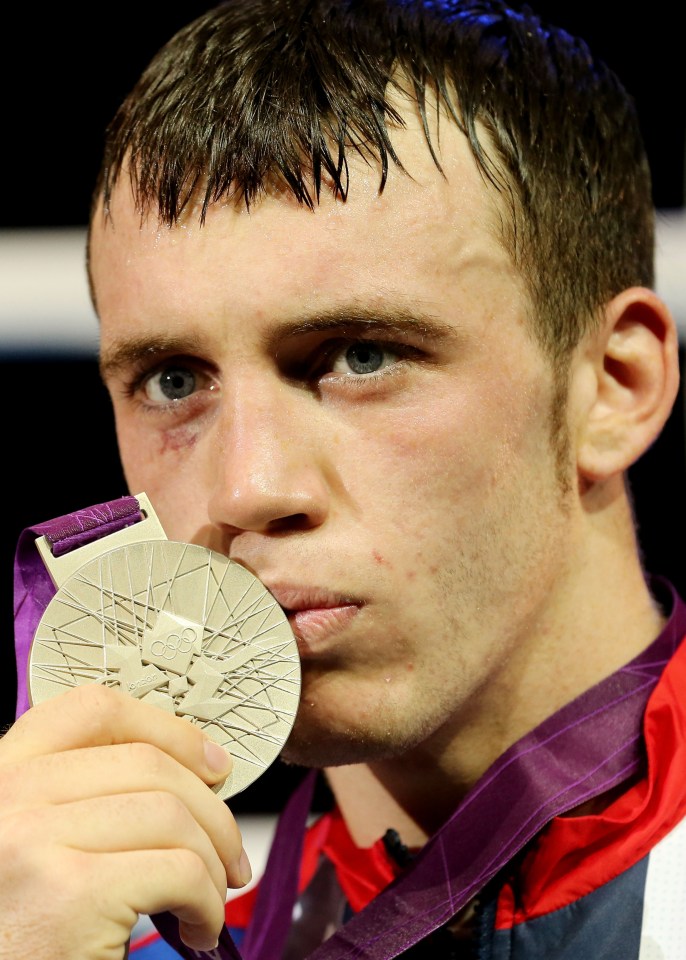 a man is holding a medal that says ' olympics ' on it