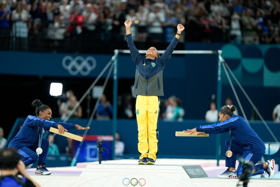 a woman stands on a podium with her arms in the air