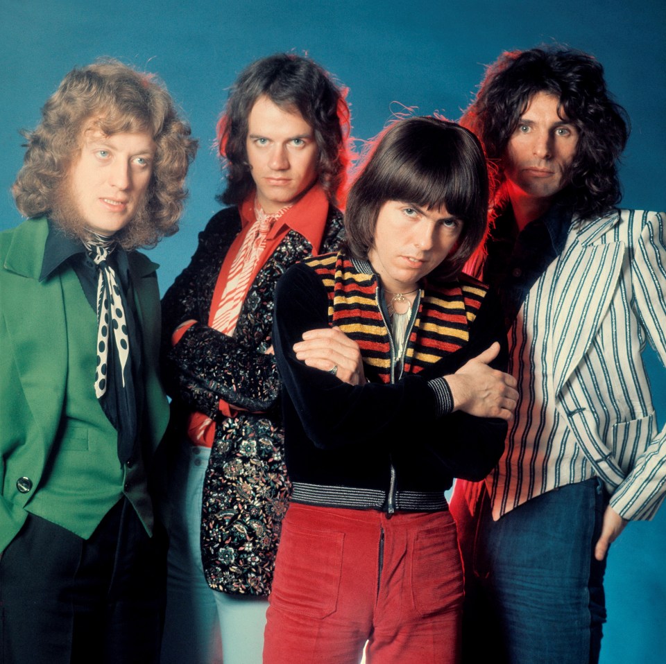 four men posing for a picture with their arms crossed