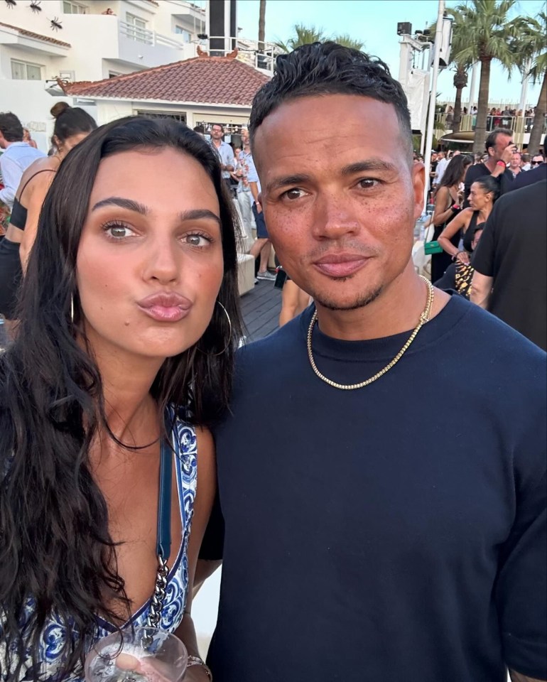 a man and a woman pose for a picture in front of a crowd