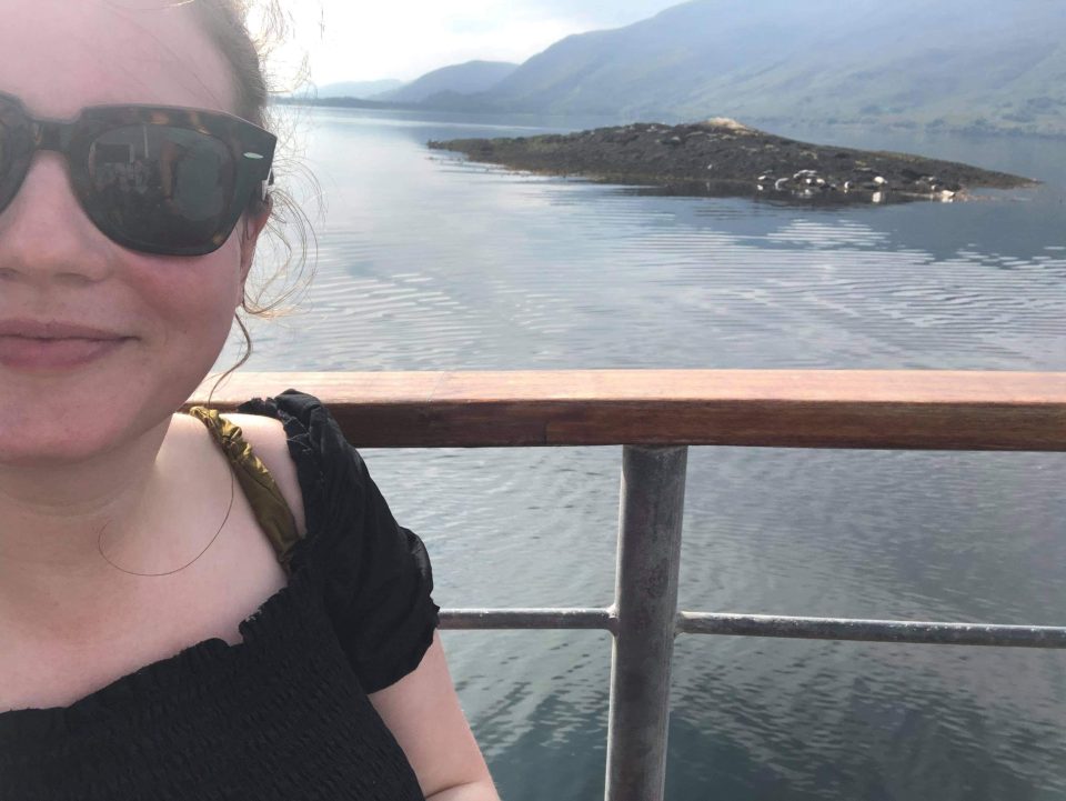 a woman wearing sunglasses looks out over a body of water