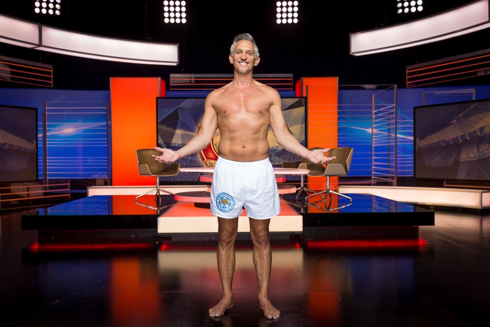 a man without a shirt is standing on a stage with his arms outstretched