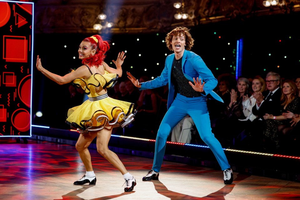 a man in a blue suit is dancing with a woman in a yellow dress